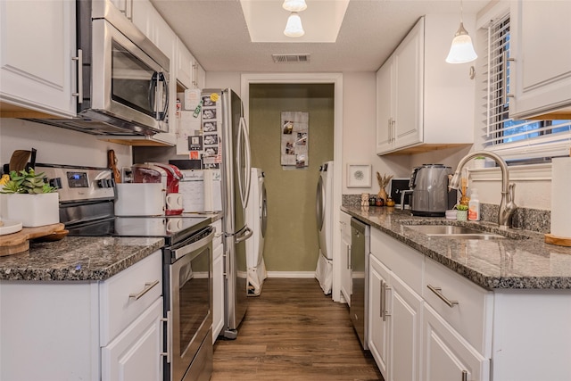 kitchen featuring sink, white cabinets, decorative light fixtures, and appliances with stainless steel finishes