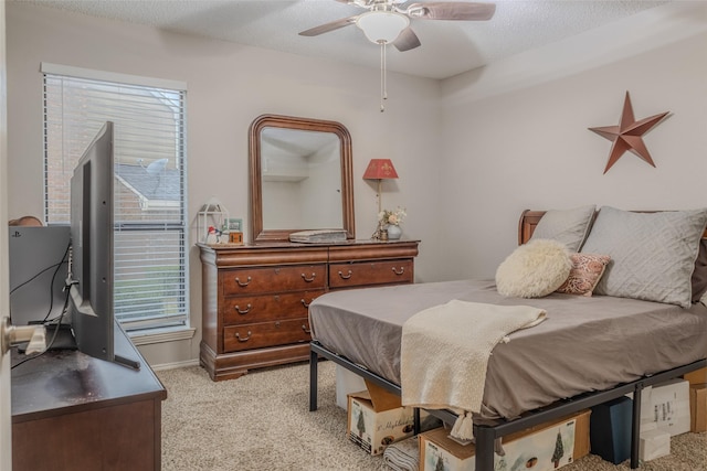 bedroom with a textured ceiling, ceiling fan, and light carpet