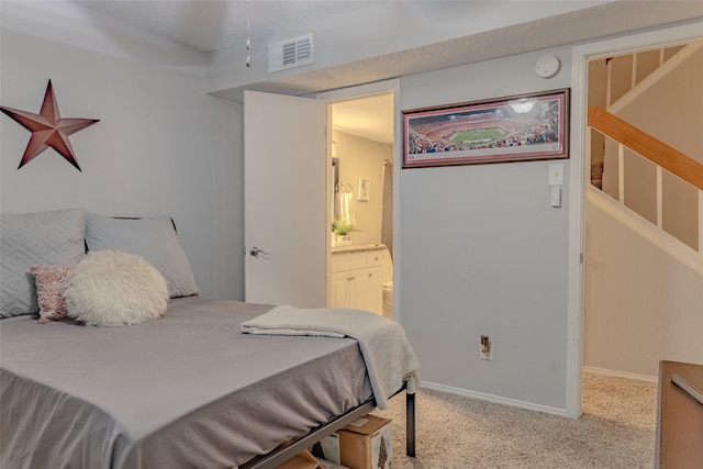 carpeted bedroom featuring ensuite bathroom