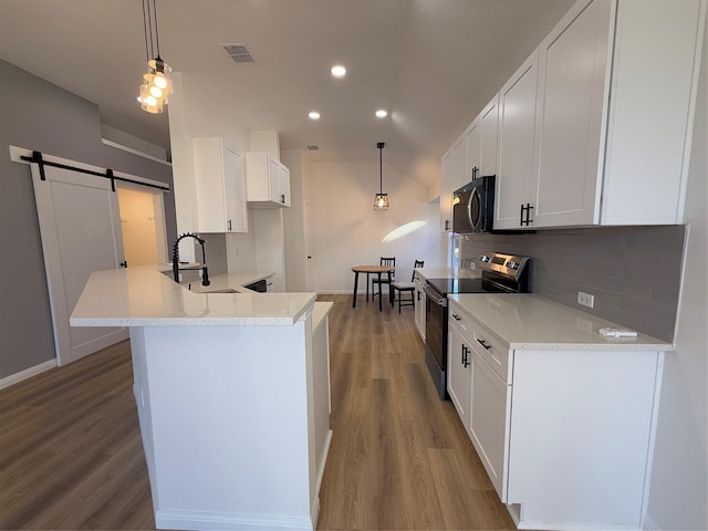 kitchen featuring white cabinetry, hanging light fixtures, stainless steel electric range, and a barn door