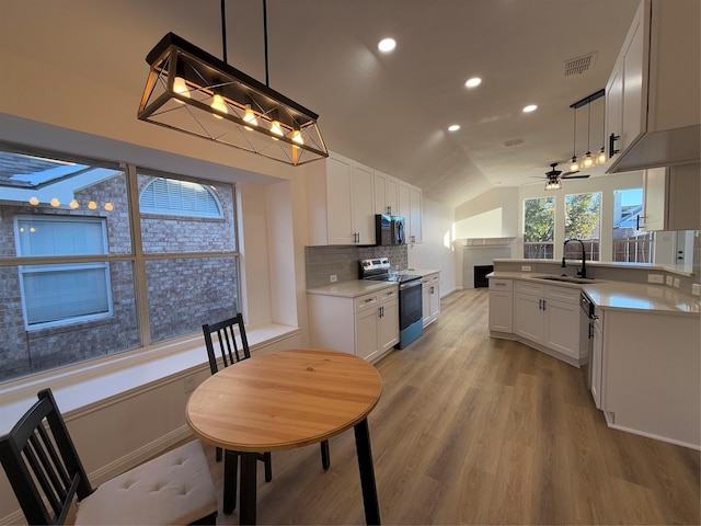 kitchen with white cabinets, pendant lighting, stainless steel range with electric cooktop, and sink