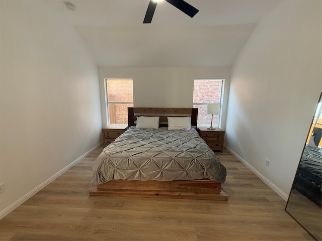 bedroom with ceiling fan, light hardwood / wood-style floors, and lofted ceiling