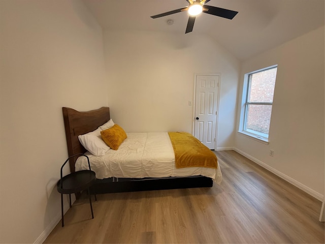 bedroom featuring hardwood / wood-style flooring, vaulted ceiling, and ceiling fan