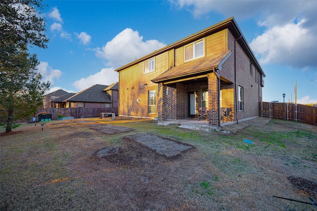 rear view of house featuring a yard and a patio