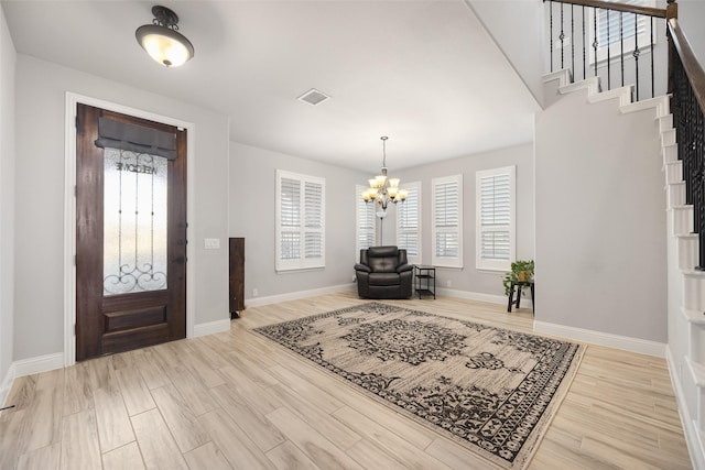 entryway with light hardwood / wood-style floors and a chandelier