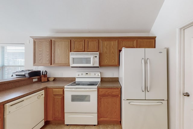 kitchen with vaulted ceiling, light tile patterned floors, and white appliances