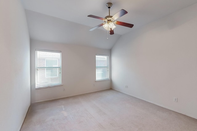 carpeted empty room featuring ceiling fan, a healthy amount of sunlight, and vaulted ceiling