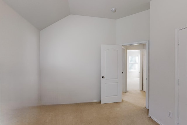 carpeted empty room featuring lofted ceiling