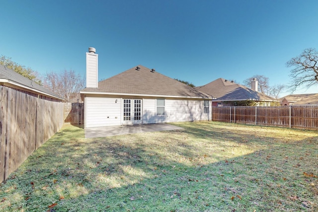 rear view of property with french doors, a patio area, and a lawn