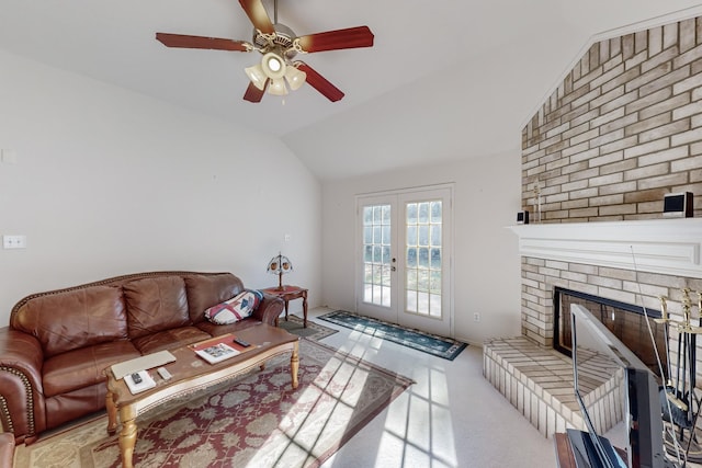 carpeted living room featuring a fireplace, ceiling fan, french doors, and lofted ceiling