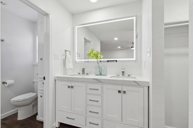 bathroom featuring vanity, hardwood / wood-style floors, ceiling fan, and toilet