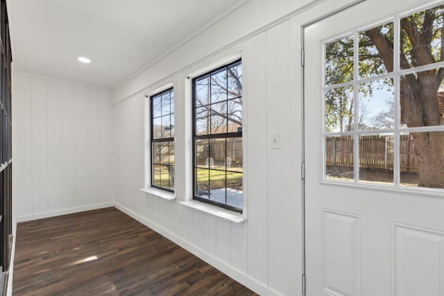 doorway with dark hardwood / wood-style flooring, plenty of natural light, and ornamental molding