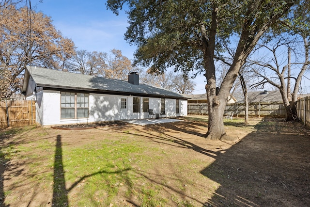 rear view of house featuring a yard