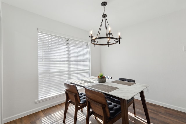 dining space featuring dark hardwood / wood-style floors and a chandelier