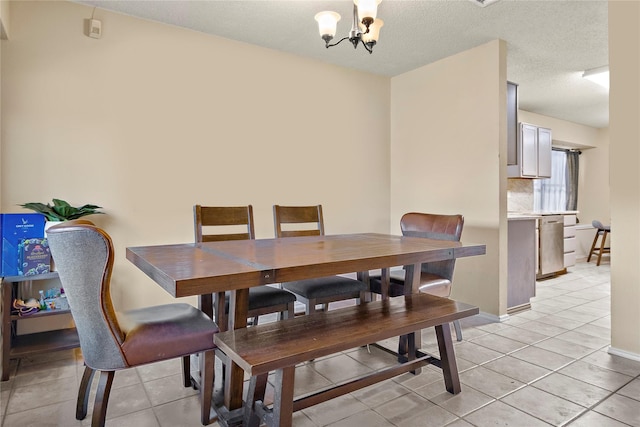 dining space featuring light tile patterned floors, a textured ceiling, and an inviting chandelier