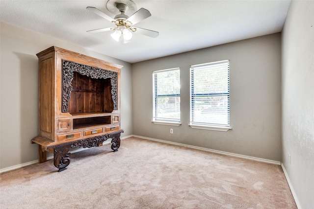 carpeted home office with ceiling fan