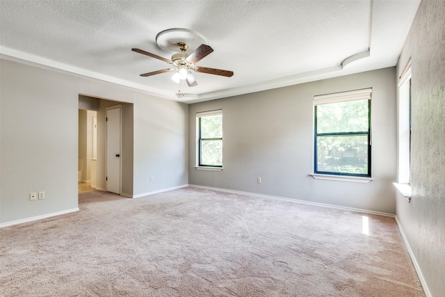 carpeted spare room featuring ceiling fan and a textured ceiling