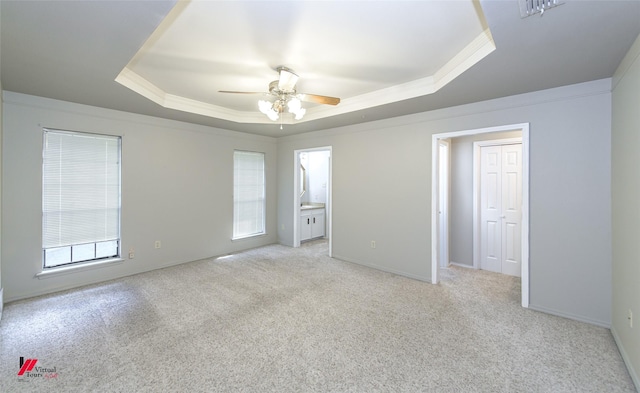 spare room with crown molding, light colored carpet, a raised ceiling, and ceiling fan