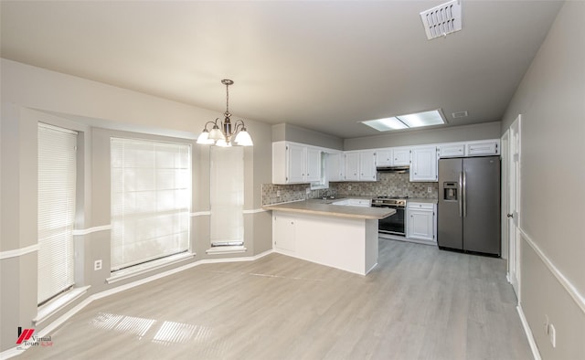 kitchen with sink, hanging light fixtures, appliances with stainless steel finishes, kitchen peninsula, and white cabinets