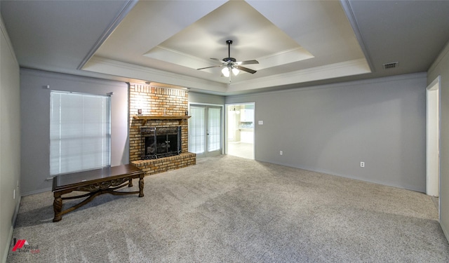 carpeted living room featuring crown molding, a fireplace, a raised ceiling, and ceiling fan