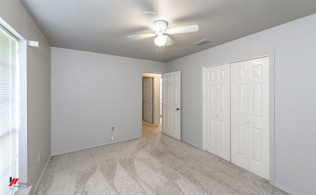 unfurnished bedroom with light carpet, a closet, and ceiling fan