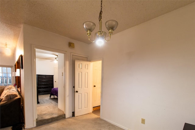 interior space with a textured ceiling and a notable chandelier