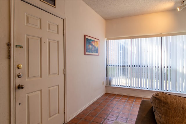 interior space with tile patterned floors, a healthy amount of sunlight, and a textured ceiling