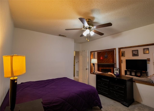 bedroom featuring ceiling fan, carpet floors, and a textured ceiling