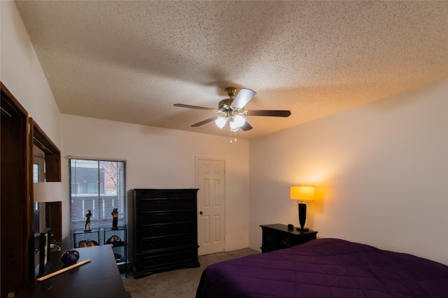 carpeted bedroom featuring ceiling fan and a textured ceiling