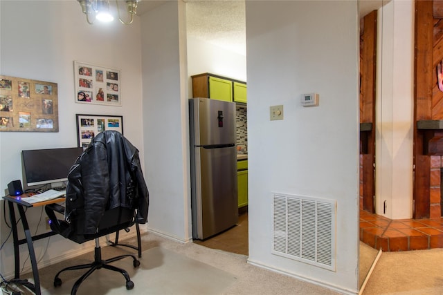 carpeted home office featuring a textured ceiling