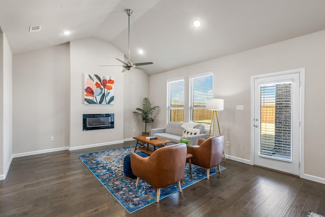 living room featuring dark wood-type flooring, ceiling fan, plenty of natural light, and vaulted ceiling