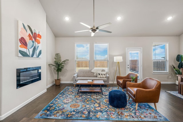 living room featuring ceiling fan and dark hardwood / wood-style floors