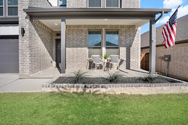 doorway to property featuring a yard and covered porch