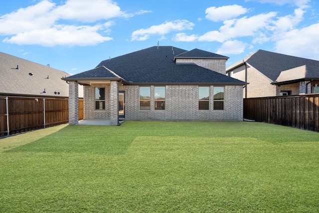 rear view of house featuring a yard and a patio