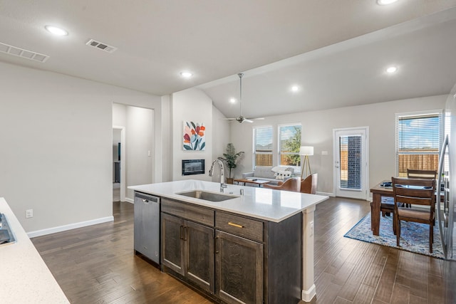 kitchen featuring dark brown cabinetry, lofted ceiling, sink, a center island with sink, and dishwasher