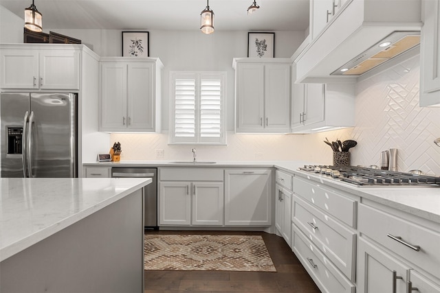 kitchen with decorative light fixtures, white cabinetry, custom range hood, and stainless steel appliances