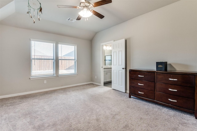 unfurnished bedroom featuring light carpet, lofted ceiling, ceiling fan, and ensuite bathroom