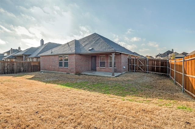 rear view of house featuring a patio area and a lawn