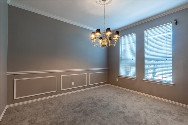 spare room with a chandelier, carpet flooring, ornamental molding, and wainscoting