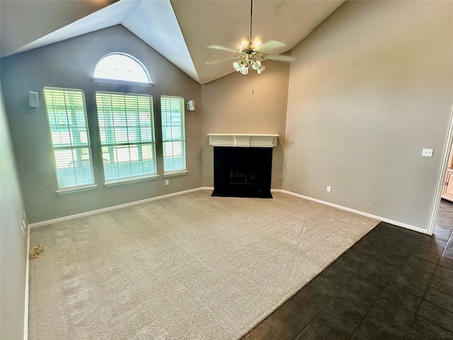 unfurnished living room featuring vaulted ceiling, a ceiling fan, a fireplace, baseboards, and dark carpet