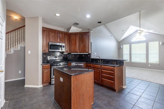 kitchen with ceiling fan, a center island, sink, vaulted ceiling, and appliances with stainless steel finishes