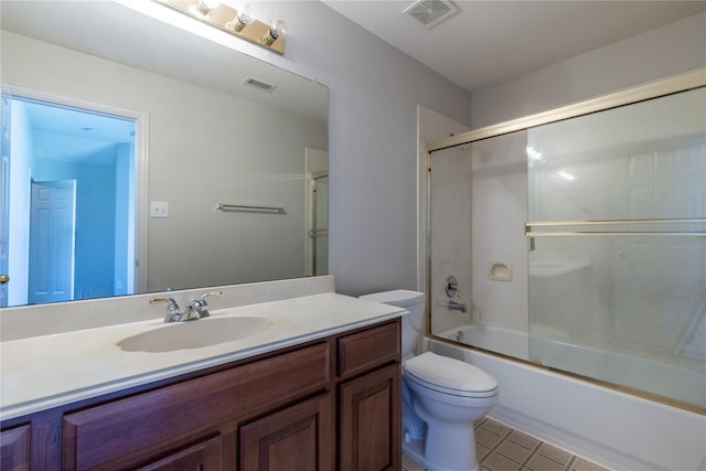 full bathroom featuring shower / bath combination with glass door, tile patterned floors, vanity, and toilet