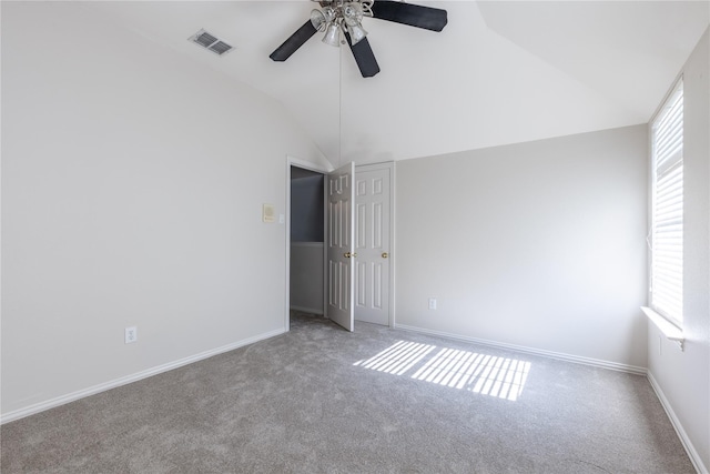 empty room featuring light carpet, ceiling fan, and vaulted ceiling