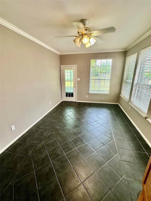 empty room featuring dark tile patterned floors, ceiling fan, crown molding, and baseboards