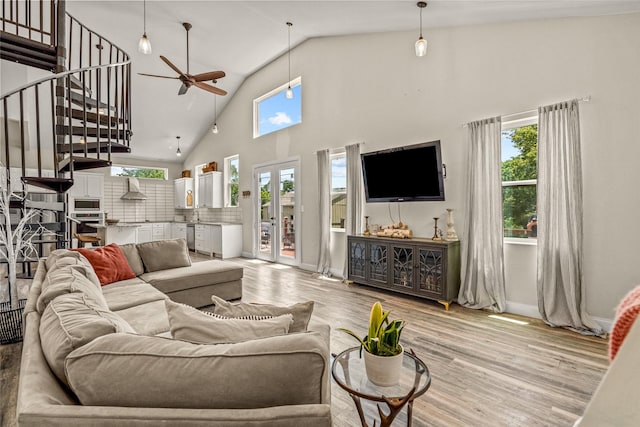 living room featuring light wood-type flooring, high vaulted ceiling, and ceiling fan