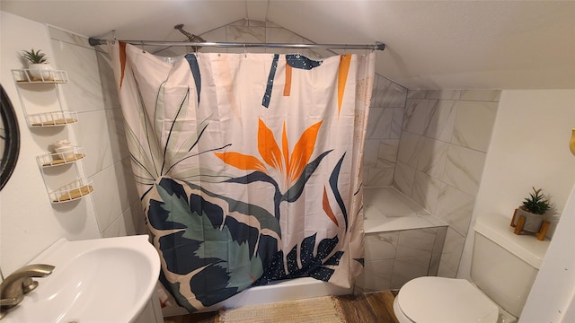 bathroom featuring toilet, sink, vaulted ceiling, and a shower with shower curtain