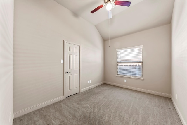 carpeted spare room with ceiling fan and lofted ceiling