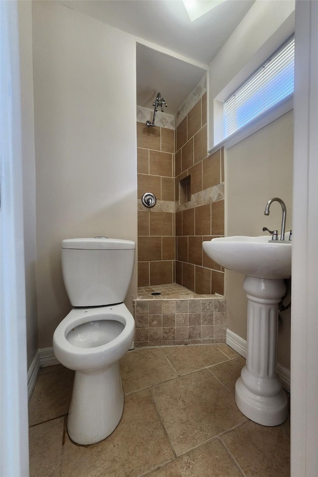 bathroom featuring toilet and tiled shower