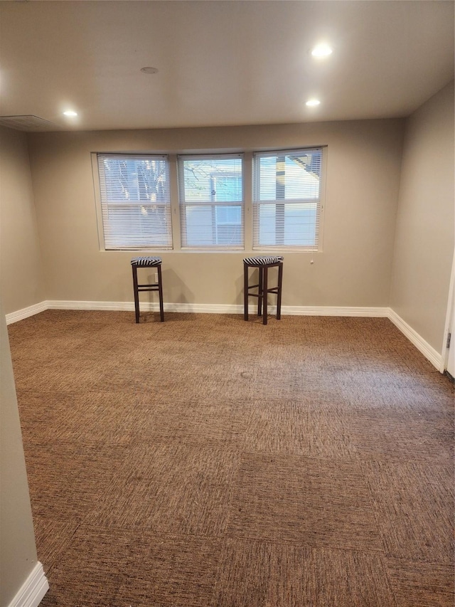 spare room featuring dark colored carpet