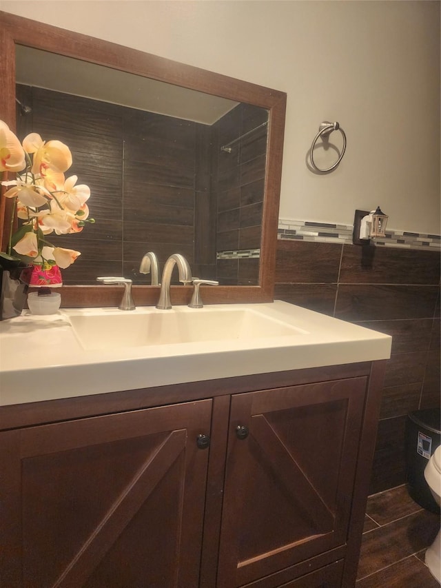 bathroom with tile walls, toilet, and vanity